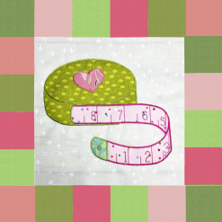 Quilt block with applique tape measure centre